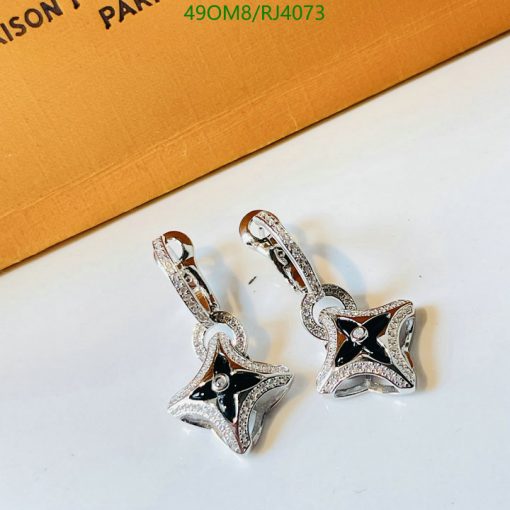 Star-shaped diamond earrings on white surface.