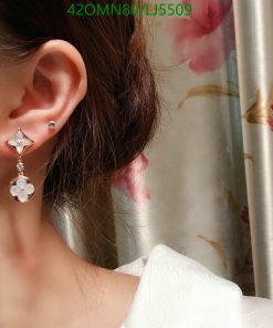 Woman wearing flower dangle earring.