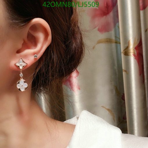 Woman wearing flower dangle earring.