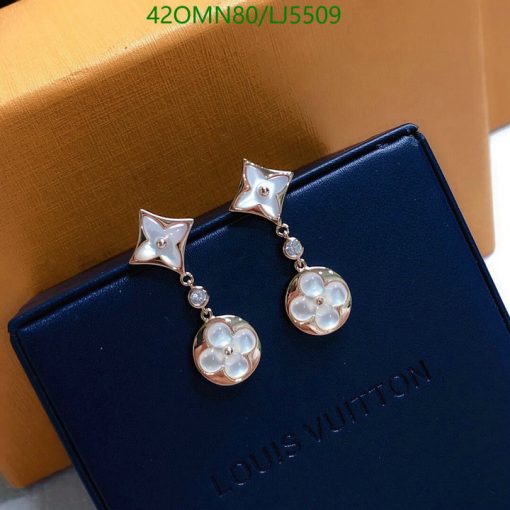 Star and flower pearl earrings on branded box