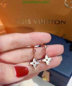 Louis Vuitton star-shaped earrings in hand.