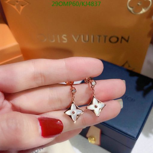 Louis Vuitton star-shaped earrings in hand.