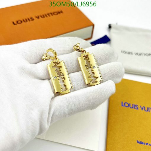 Gold designer label keychains on white glove.