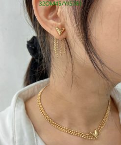 Gold chevron earrings and necklace on a woman.