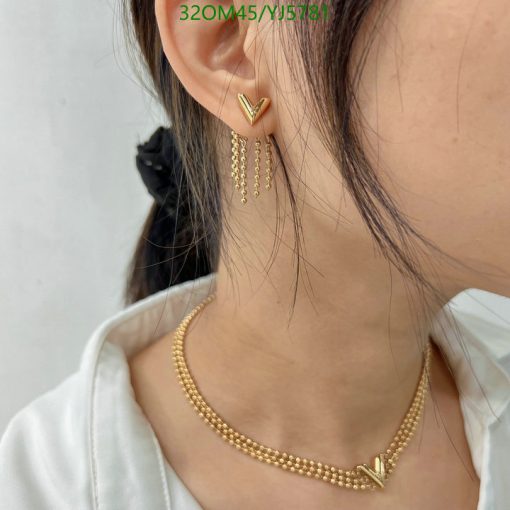 Gold chevron earrings and necklace on a woman.