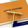 Louis Vuitton book and gold jewelry on white.