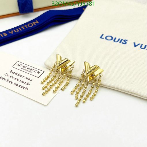 Gold tassel earrings on white surface with brand pouch.