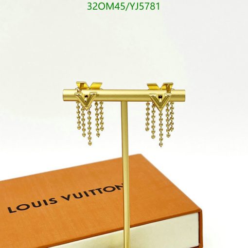 Gold tassel earrings on display stand.