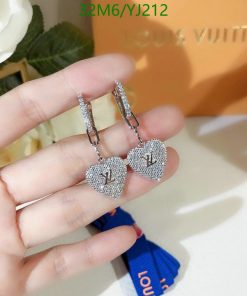 Heart-shaped designer earrings in hand.