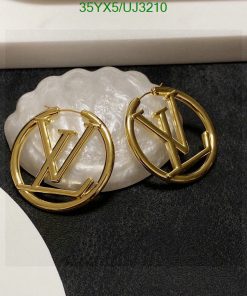 Gold designer logo earrings on white stand.