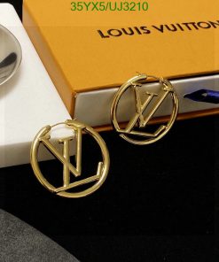 Gold designer logo earrings on box.