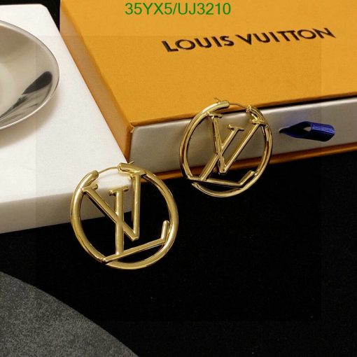 Gold designer logo earrings on box.