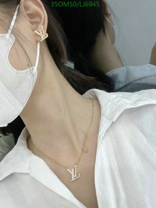 Woman wearing designer initial earrings and necklace.