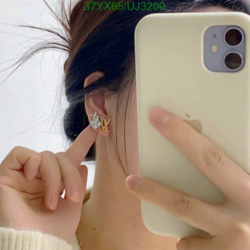 Person showing earring while taking selfie with phone.