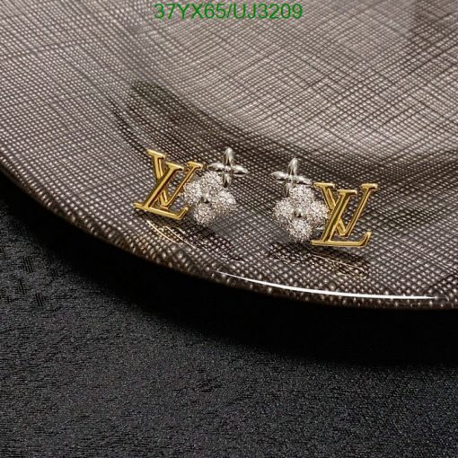 Designer logo earrings on textured surface.