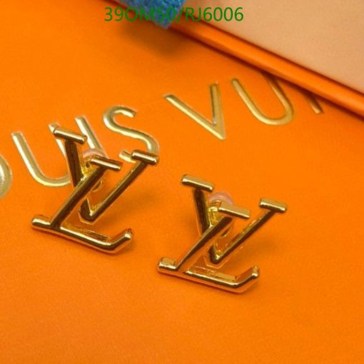 Gold luxury brand initials on orange background.