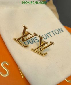 Gold designer cufflinks on branded display cushion.