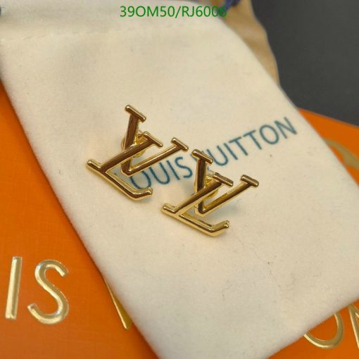 Gold designer cufflinks on branded display cushion.