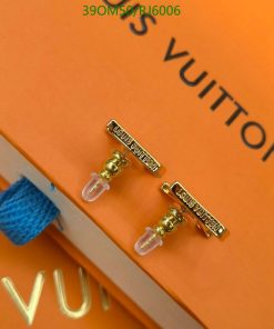 Louis Vuitton earrings on orange background.