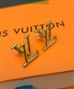 Designer logo earrings on orange background.