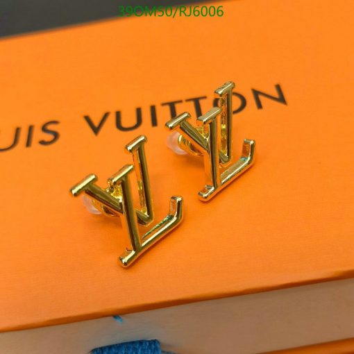 Designer logo earrings on orange background.