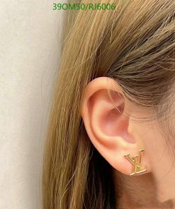 Woman wearing designer logo earring.