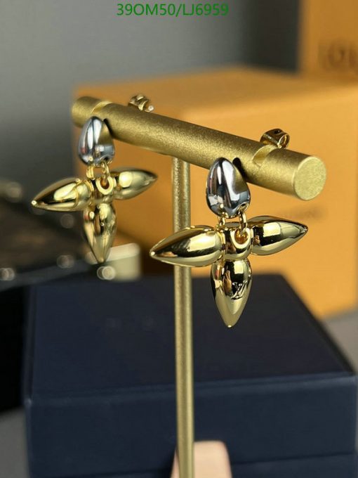 Gold and silver propeller-shaped earrings displayed.