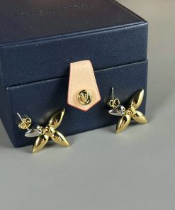 Designer jewelry box with gold-tone flower earrings.