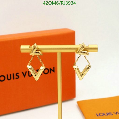 Gold Louis Vuitton earrings on display stand.