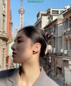 Woman with urban backdrop, sunny day.