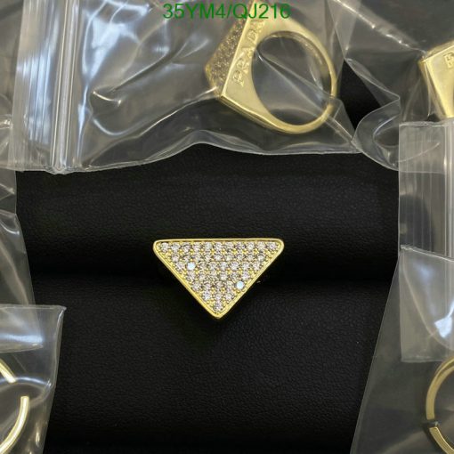 Gold triangle ring with diamonds on black surface.