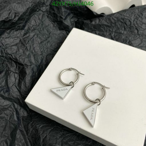 Silver designer triangular hoop earrings on white box.