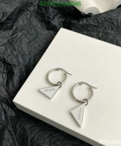 Silver triangle logo earrings on white box.