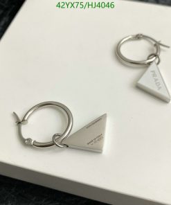 Designer silver triangular hoop earrings on white.