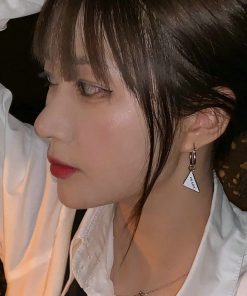 Woman with earring, red lipstick, white shirt.