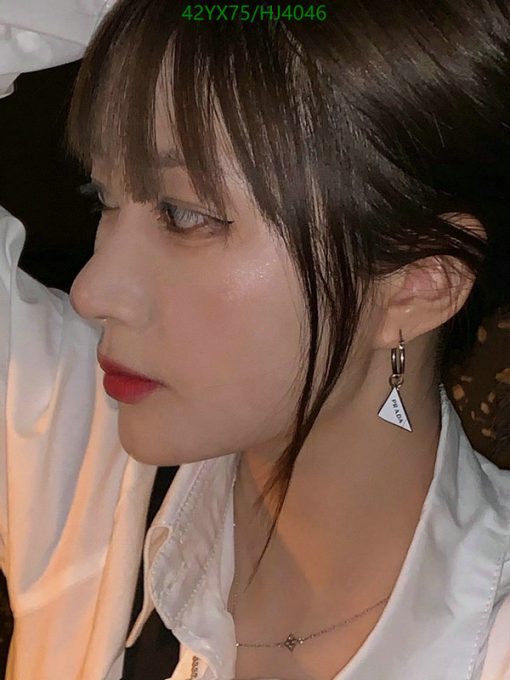 Woman with earring, red lipstick, white shirt.