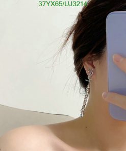 Person showing feather earring with phone.