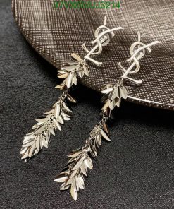 Silver leaf dangle earrings on textured background.