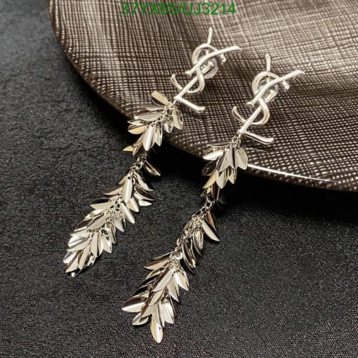 Silver leaf dangle earrings on textured background.