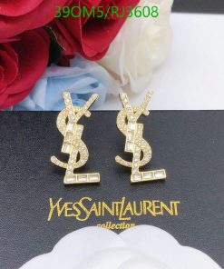 Gold designer logo earrings with crystals on black background.