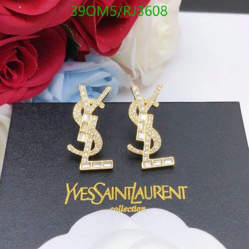 Gold designer logo earrings with crystals on black background.