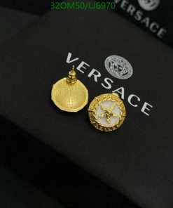 Versace gold earrings on branded black packaging.