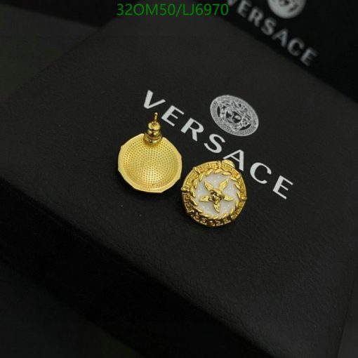 Versace gold earrings on branded black packaging.