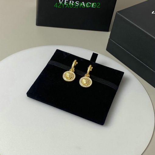 Gold coin pendant earrings on black velvet stand.