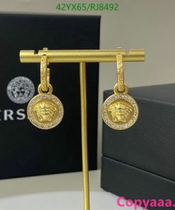 Gold lion medallion earrings with packaging.