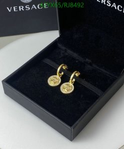 Gold designer earrings in black presentation box.