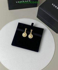 Gold pendant earrings on black stand with box.