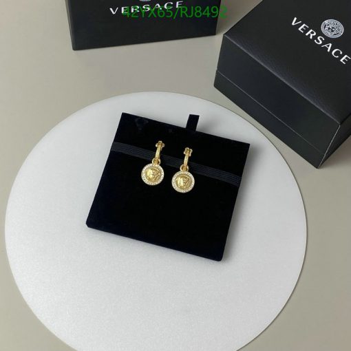 Gold pendant earrings on black stand with box.