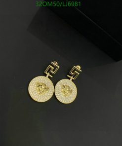 Gold rose-designed earrings with diamonds on black background.