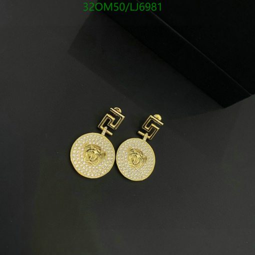 Gold rose-designed earrings with diamonds on black background.